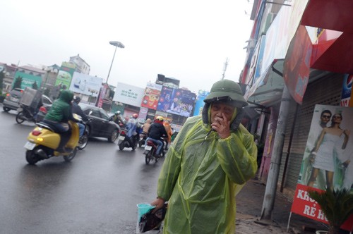 Cụ ông này còn mặc thêm cả áo mưa để chống chọi lại cái rét cắt da cắt thịt.